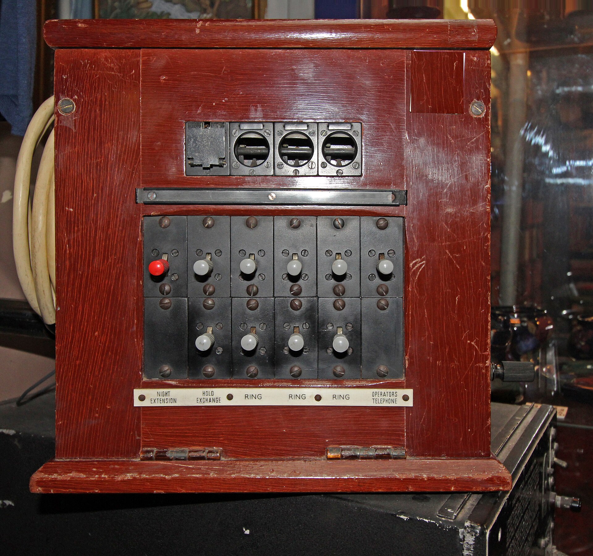 A small wooden telephone exchange from the 1940s with ring and hold switches